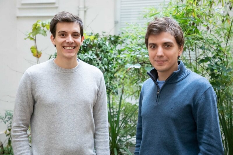 Jean Ashton e Arnaud Albalat, os dois fundadores da Galadrim, de pé em frente a uma parede verde.