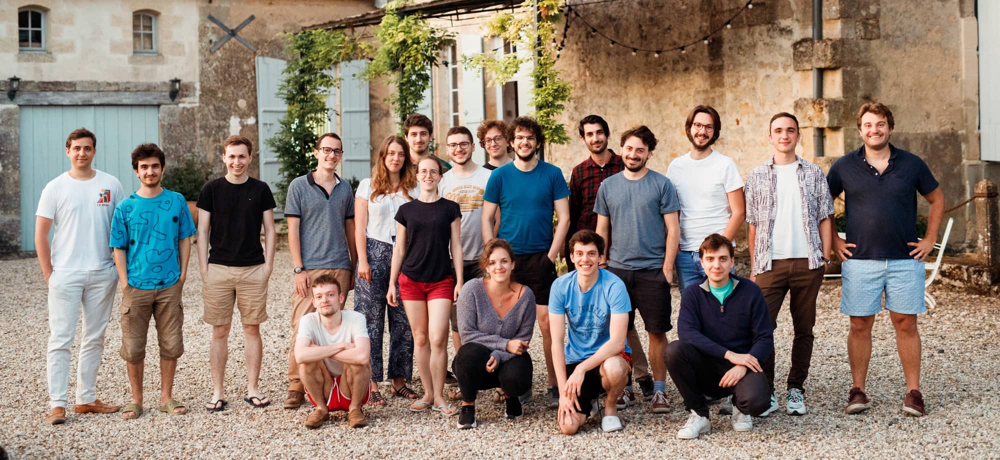 A equipe da Galadrim reunida no pátio de um prédio de pedra, durante um encontro da empresa.