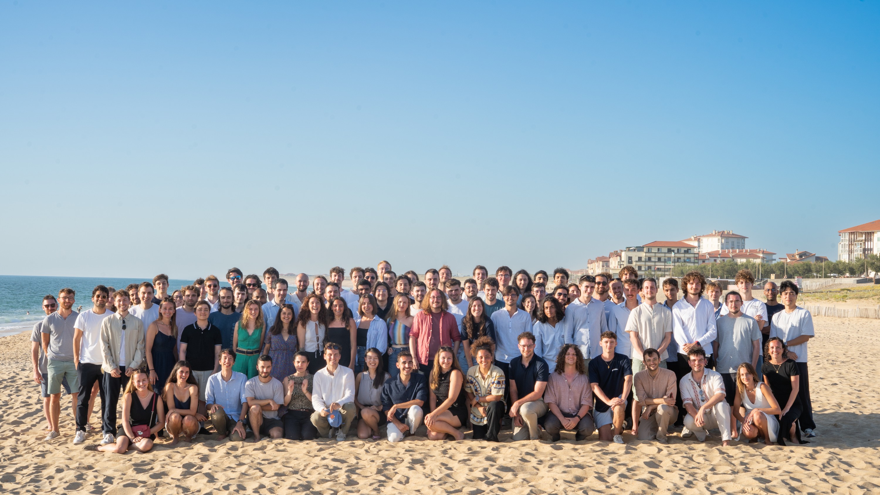 Os 180 Galadrimers reunidos em uma praia, durante o encontro anual da empresa.